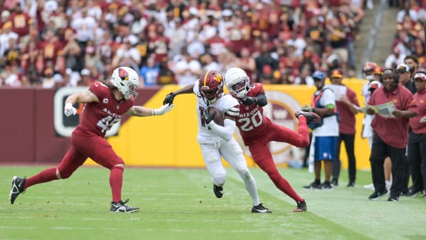 Washington Commanders wide receiver Terry McLaurin (17) cuts in-between Arizona Cardinals linebacker Dennis Gardeck (45) and cornerback Marco Wilson (20) as assistant head coach/offensive coordinator Eric Bieniemy look on during the first half at FedExField.